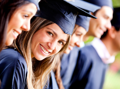 Woman standing out from a graduation group smiling.